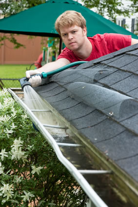 man cleaning gutters n san diego house